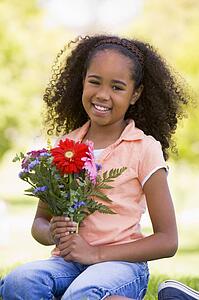 Young girl holding flowers and smiling