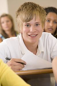 Student in class taking notes (selective focus)