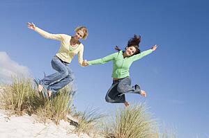 Young woman jumping on a sand hill
