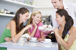 Man offering sweet treats to three young women