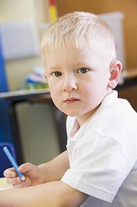 Student in class writing in notebook (selective focus)