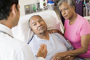 Senior Couple Talking To Doctor, Looking Worried