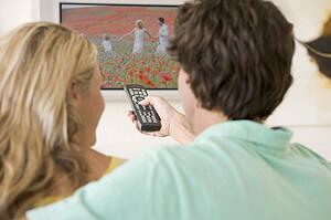 Couple in living room watching television