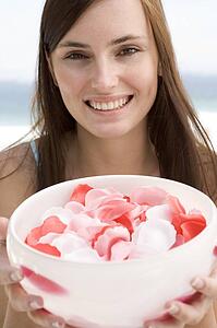 Woman holding a bowl of rose petals