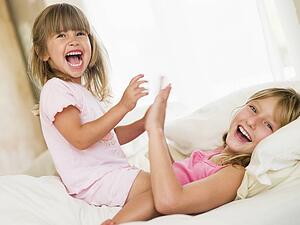 Young Girl Being Woken Up By Her Little Sister