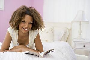 Teenage Girl Lying On Bed Reading