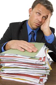 Businessman Overwhelmed By Paperwork