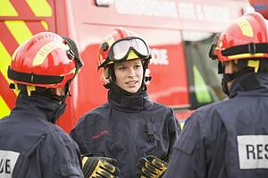 Three rescue workers talking by rescue vehicle