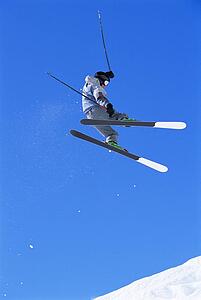 Skier doing jump on snowy hill
