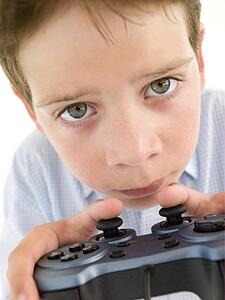 Young boy using videogame controller and concentrating