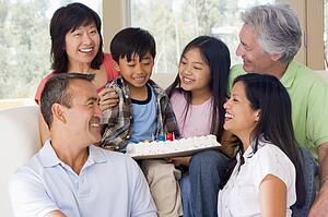 Family in living room with cake smiling