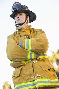 Firewoman standing outdoors wearing helmet