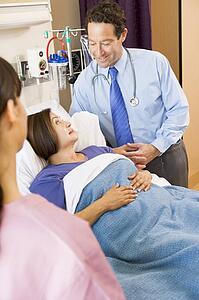 Doctor Standing In Hospital Room With His Patient