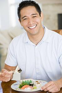 Man Enjoying Chinese Food With Chopsticks