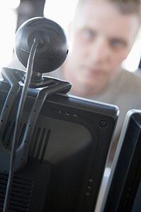 Shot of a man behind a computer and web camera
