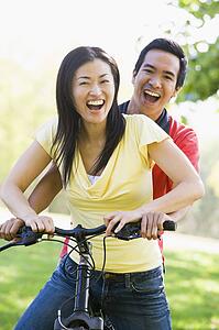 Couple on a bike outdoors smiling