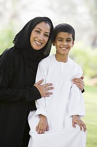 Woman and young boy outdoors in a park smiling (selective focus)