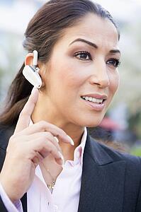 Woman wearing headset outdoors smiling (selective focus)