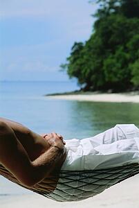 Man in a hammock outdoors on the beach (selective focus)