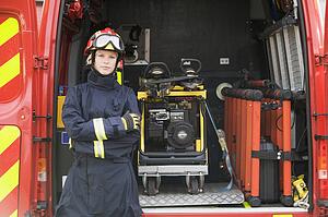 Rescue worker standing by open back door of rescue vehicle