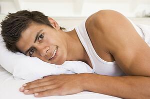Man lying in bed smiling