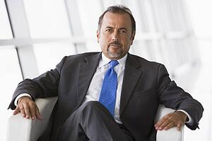 Businessman sitting indoors (high key/selective focus)