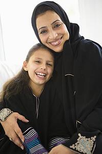 Grandmother with grandaughter in living room smiling