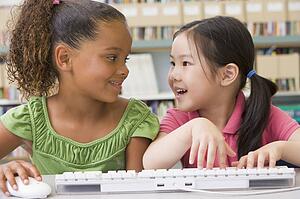 Two students in class at computer keyboard