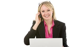 Businesswoman Sitting In Front Of Laptop Talking On Mobile Phone 