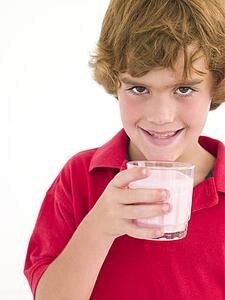 Young boy with glass of milk smiling