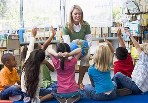 Teacher in class with students volunteering