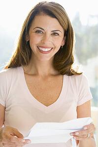 Woman reading letter smiling