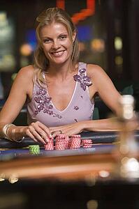 Woman in casino playing roulette smiling (selective focus)