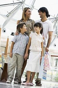 Family standing in mall smiling (selective focus)