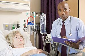 Doctor Making Notes About Patient, Looking Serious