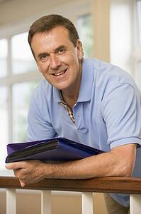Teacher in corridor leaning on railing