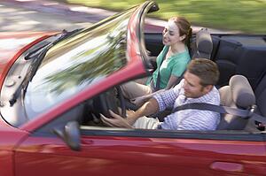 Couple in convertible car smiling