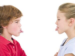 Brother and sister sticking tongues out at each other