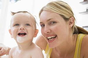 Mother giving baby bubble bath smiling