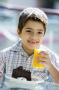 Young boy at restaurant eating dessert and smiling (selective focus)