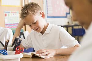 Students in class reading books (selective focus)
