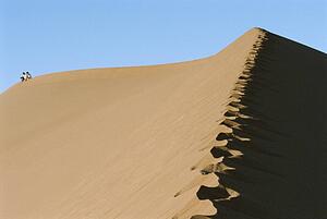 Couple outdoors sitting in the desert (far away)