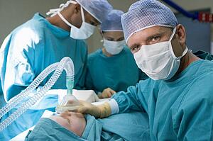 Three Surgeons Operating On A Patient