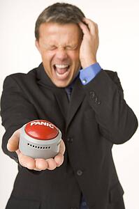 Businessman Holding A Panic Button 