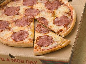 Pepperoni Pizza in a Take Away Box with a Cut Slice