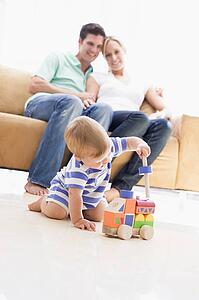 Couple in living room with baby smiling