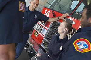 Four firefighters talking by fire engine