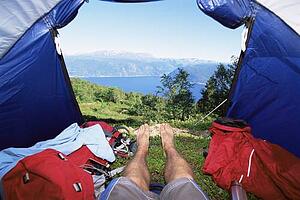 Man's legs in a tent overlooking scenic location