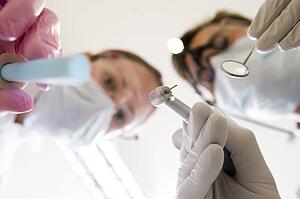 Dentist and assistant holding pick and mirror