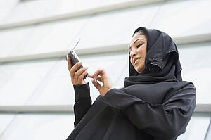 Businessman outdoors by building using PDA